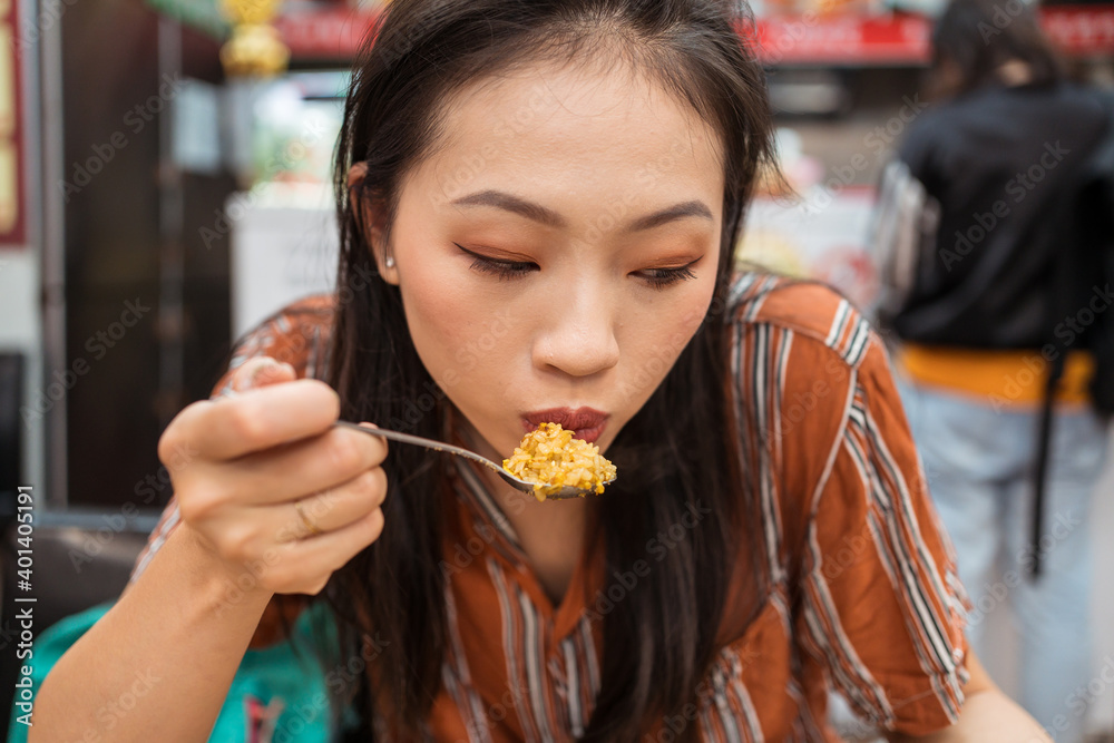 Portrait of beautiful Asian woman eating fried rice in restaurant