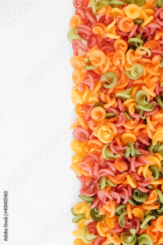 Multicolored pasta scattered on a white background. Top view. Copy  empty space for text