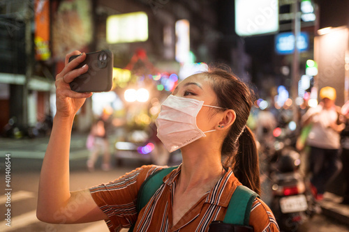 Obraz na płótnie Asian girl taking video during Ghost Festival Taoist religious celebration in the streets of Hsinchu w salonie