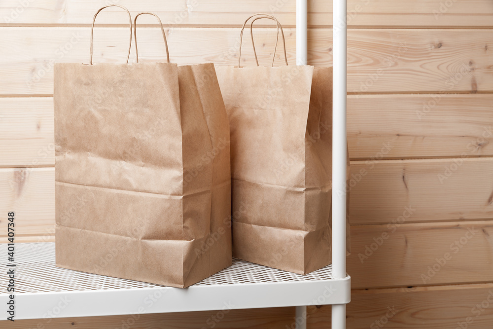 Two recycling paper bags stand on a white shelf Two recycling paper bags stand on a white shelf