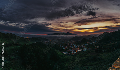 Atardecer en una isla con volcán, con vistas a un pueblo en un valle © YerayS