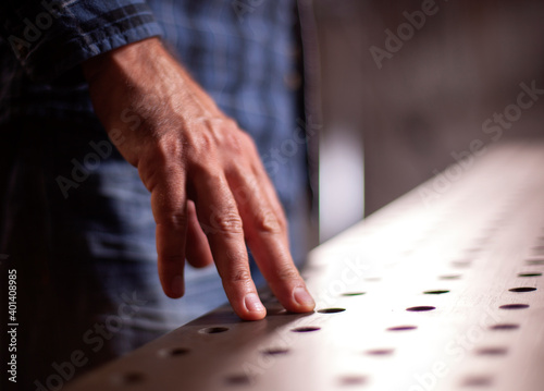 close-up of a man's hand resting on a metal table.