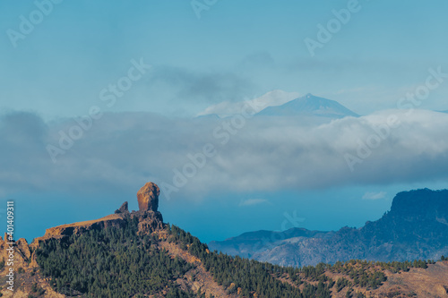 Paisaje de montaña con mar de nubes y un volcán en segundo plano