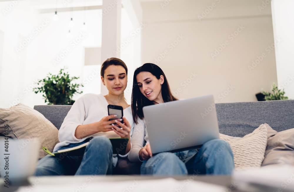 Girlfriends using gadgets spending time together Girlfriends using gadgets spending time together