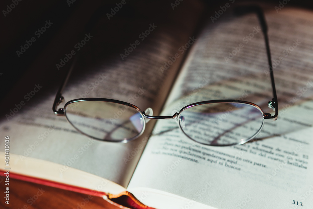 Reading glasses on top of an open book. Reading glasses. Study and reading. Reading glasses on top of an open book. Reading glasses. Study and reading.