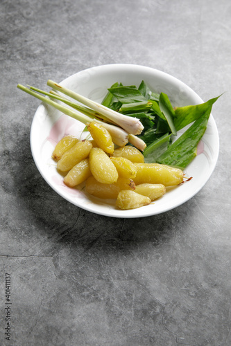 a bow containing a slice of turmeric leave, lemon grass and Averrhoa bilimbi