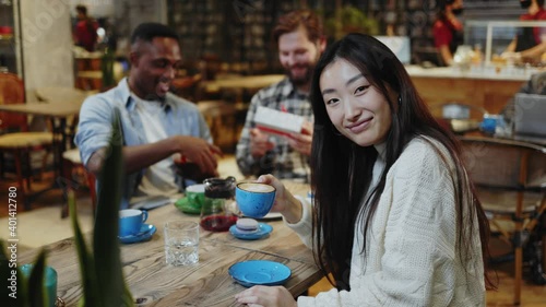 Wallpaper Mural Asian cheerful pretty woman drinking cappuccino in cup smiling positively staying with friends on social party casual meeting coffeshop interior. Portraits. Torontodigital.ca