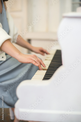 Person playing on white piano