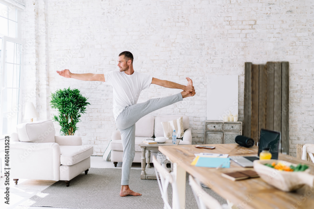 Focused man doing yoga in cozy room Focused man doing yoga in cozy room