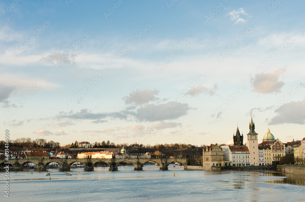 panoramic view over the river of Prague in a winter sunny day where light makes buildings seem magical on the golden hour