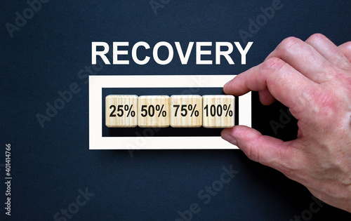 Recovery symbol. Loading percentages with hand putting wood cube in progress bar. Word 'recovery'. Business and recovery concept. Copy space. photo