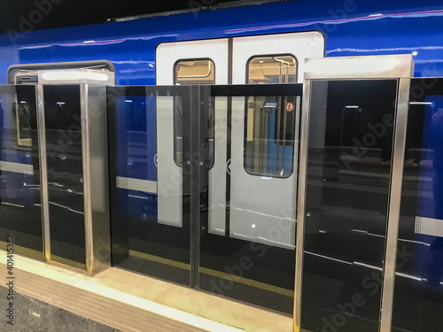subway with increased security. new metro stations. double security, automatic doors before entering the train. a blue modern train with glass doors arrived on the way. boarding passengers