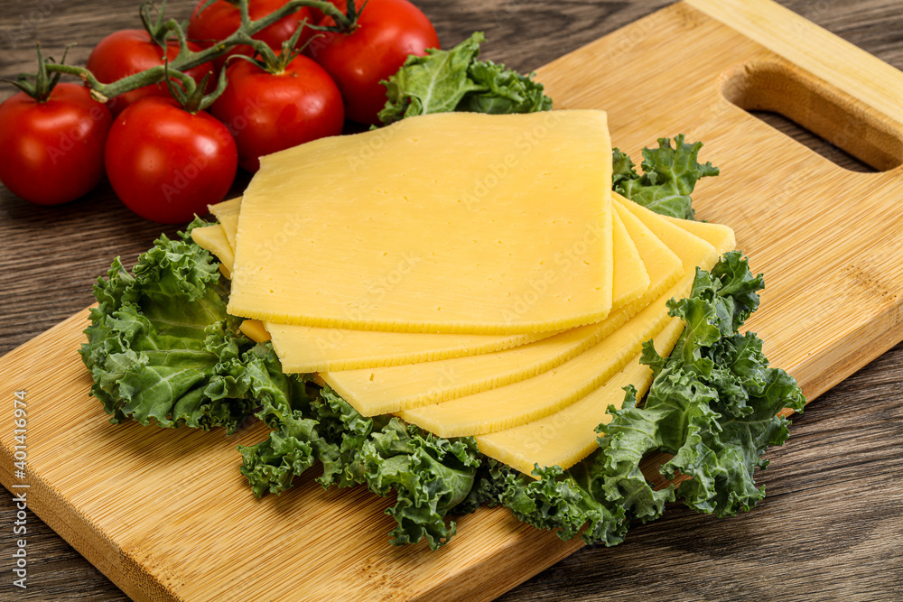 Sliced Gauda cheese over board Sliced Gauda cheese over board