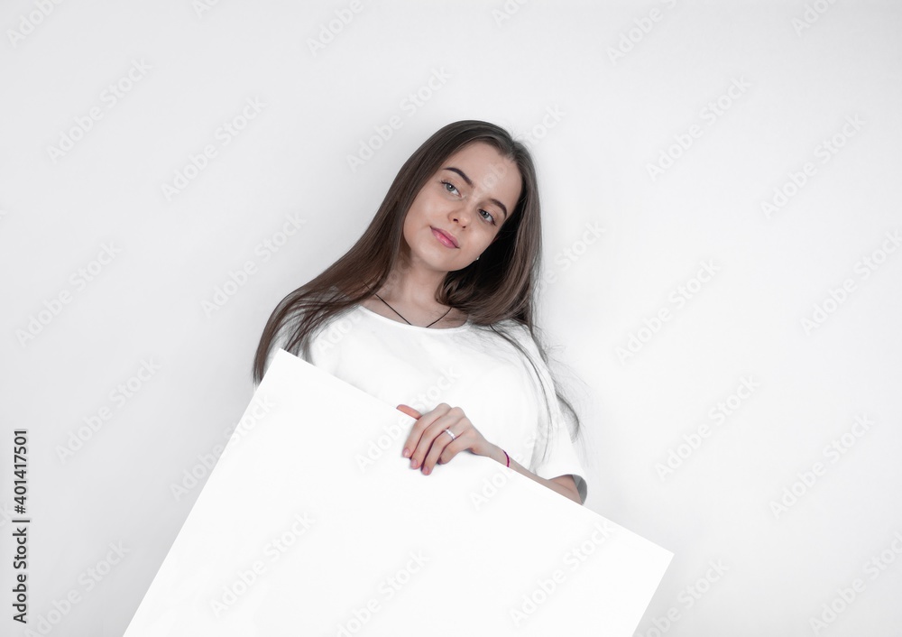 Demonstrating a blank sheet of paper, a beautiful woman attracts the eye. Demonstrating a blank sheet of paper, a beautiful woman attracts the eye.