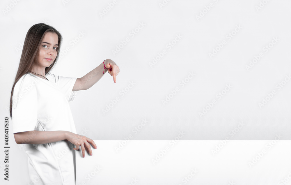 Teen girl showing a big blank poster shows a thumb down.