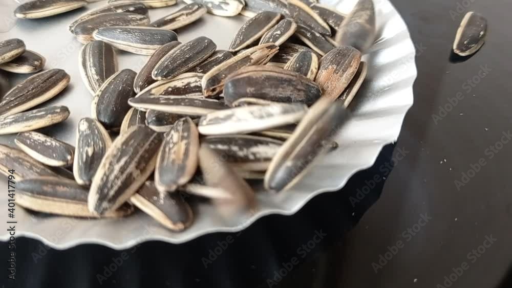 a bunch of sunflower seeds on a white paper plate a bunch of sunflower seeds on a white paper plate