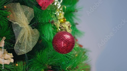 beautiful lush Christmas tree hand hangs the ball on the Christmas tree, decorate the Christmas tree.