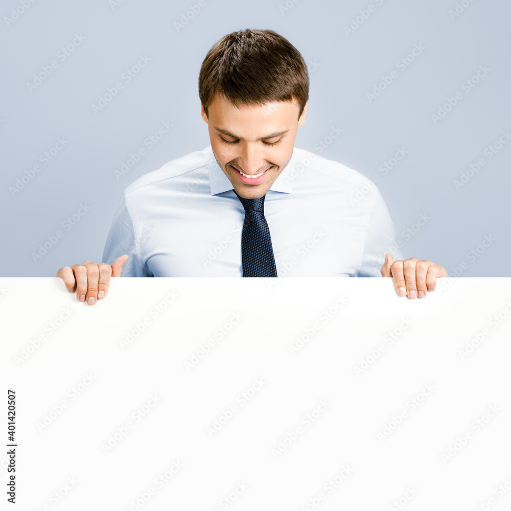 Business man showing blank signboard, over grey Business man showing blank signboard, over grey