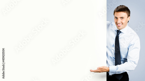 Business man showing blank signboard, over grey