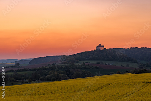 Germany, castle in a landscape with fields, mountains and nature. Beautiful yellow fields with rapeseed and meadow. Sunset in a landscape