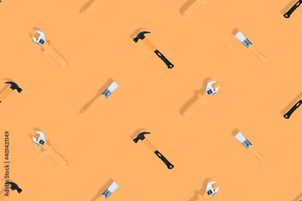 Tools seamless pattern. Tools: construction brushes, hammer, wrench on an orange background. Tools seamless pattern. Tools: construction brushes, hammer, wrench on an orange background.