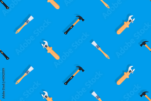 Tools seamless pattern. Tools: construction brushes, hammer, wrench on a blue background.