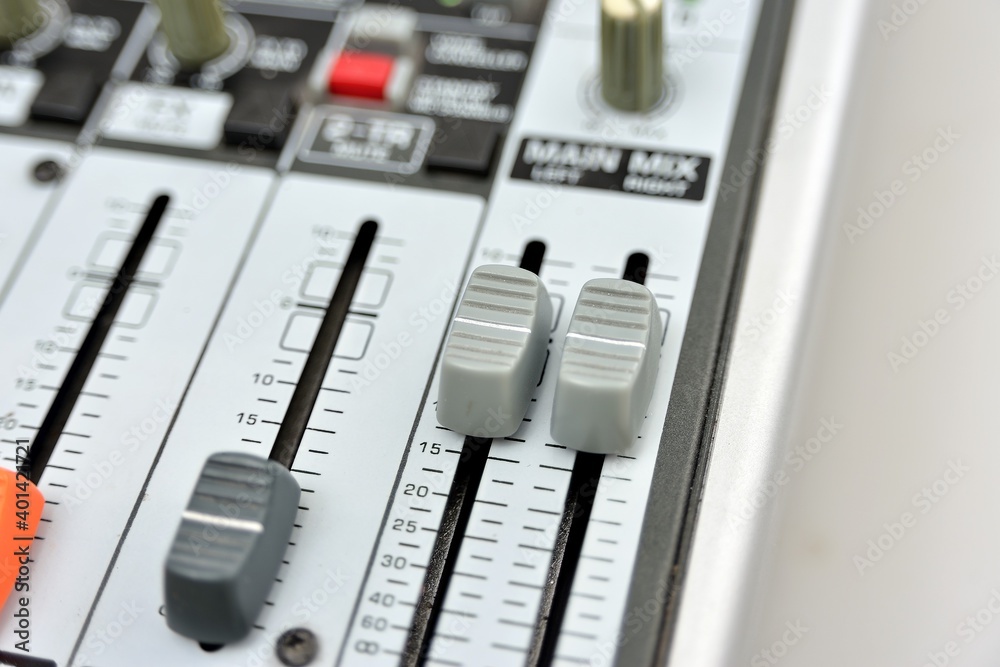 Close-up of two gray faders on a mixing console. Close-up of two gray faders on a mixing console.