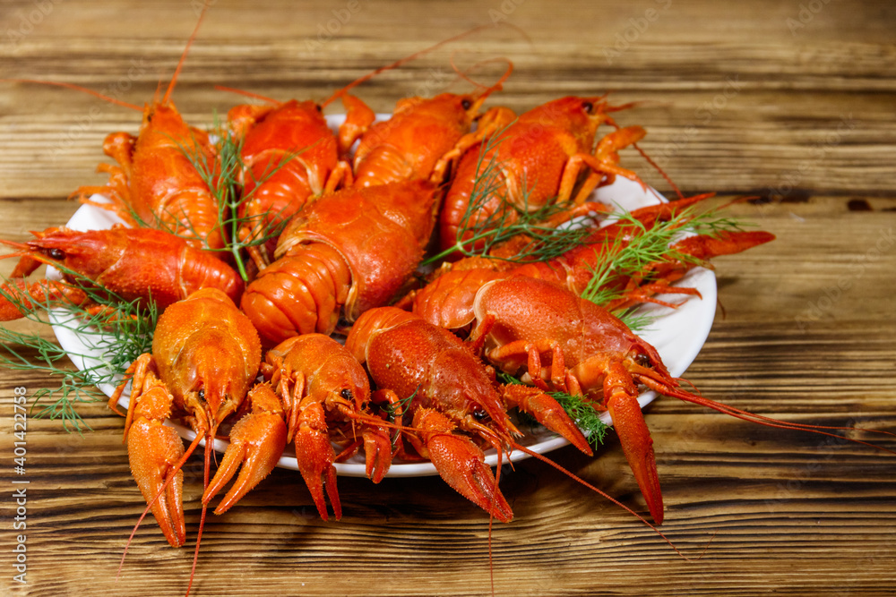 Boiled crayfish in plate on wooden table Boiled crayfish in plate on wooden table