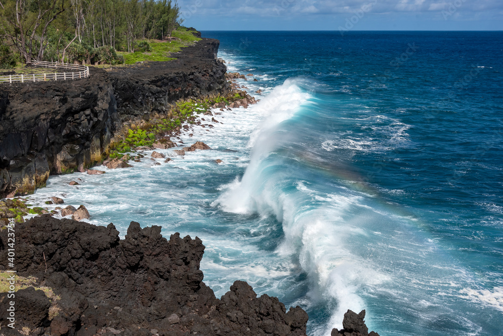 Wave crashing on a tropical and volcanic cape of Cape Mechant in Reunion island, France.