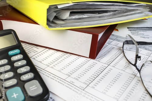 two folders lie on the documents near the calculator and eyeglasses for vision. Business and financial concept
