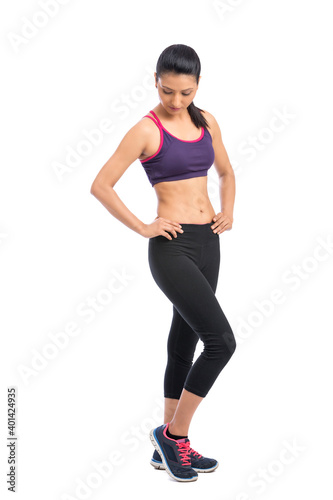 Attractive fitness woman in sport style posing isolated on white background.