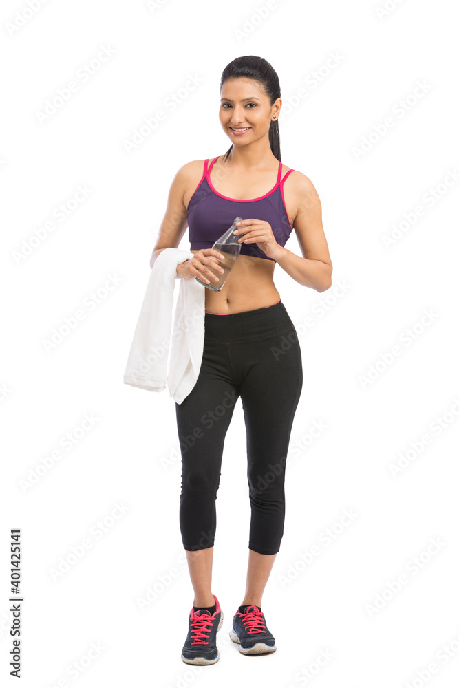 Beautiful fit female model holding a bottle of water, wearing towel and fitness clothing. Beautiful fit female model holding a bottle of water, wearing towel and fitness clothing.