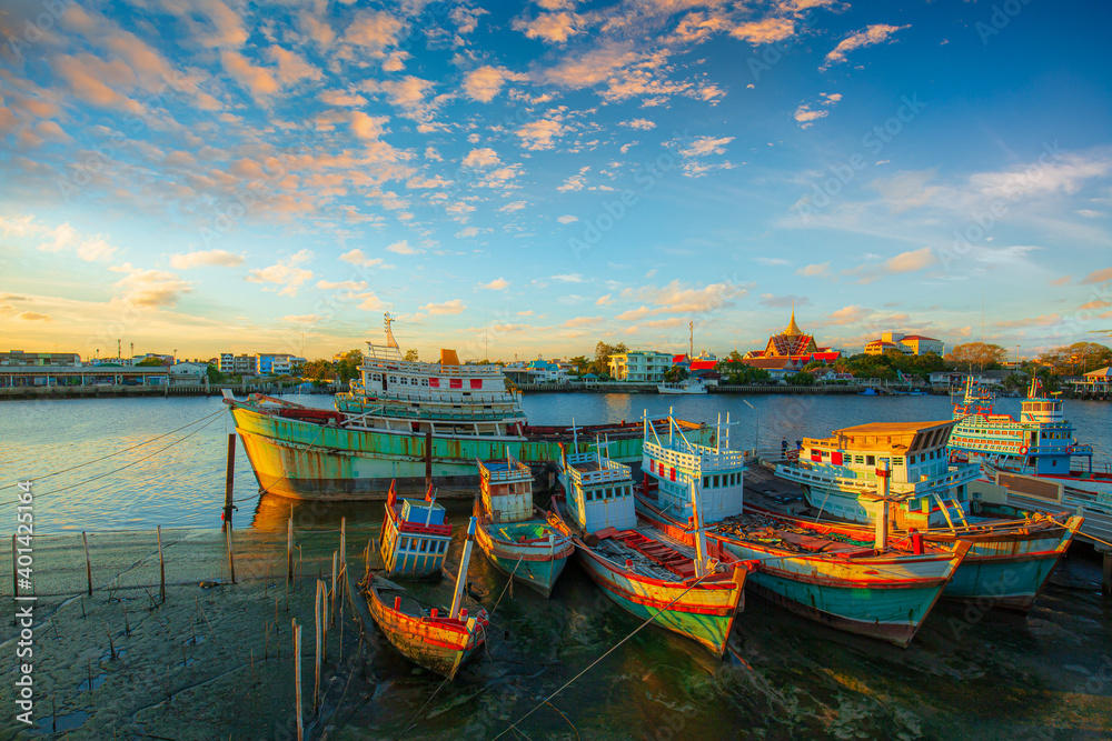 fishing boats under a sunset in a fishing harbor