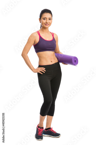 Young attractive woman holding a pink yoga mat. Isolated on white
