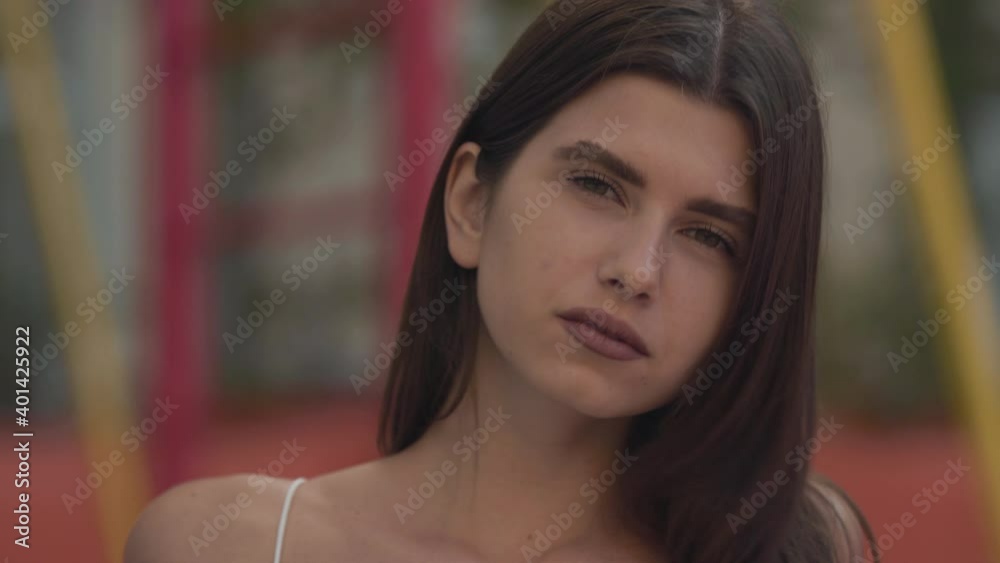 Portrait of tanned slim gorgeous woman looking at camera. Close-up of confident charming brunette Caucasian lady posing outdoors on windy summer day. Natural beauty concept. Portrait of tanned slim gorgeous woman looking at camera. Close-up of confident charming brunette Caucasian lady posing outdoors on windy summer day. Natural beauty concept.