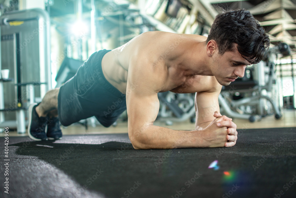 Handsome shirtless guy doing plank exercise in gym. Handsome shirtless guy doing plank exercise in gym.