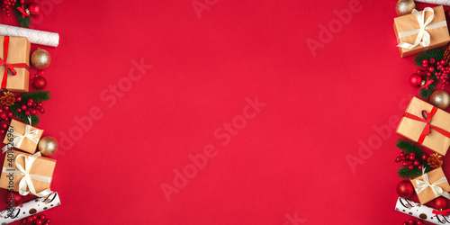 Festive New Year and Christmas picture for banners and greeting cards on a red background. Top view on christmas presents, christmas toys and balls. Image for holiday season and sales.