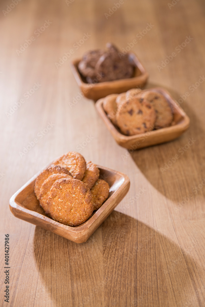 wooden tray with many different types of cookies on wooden background.