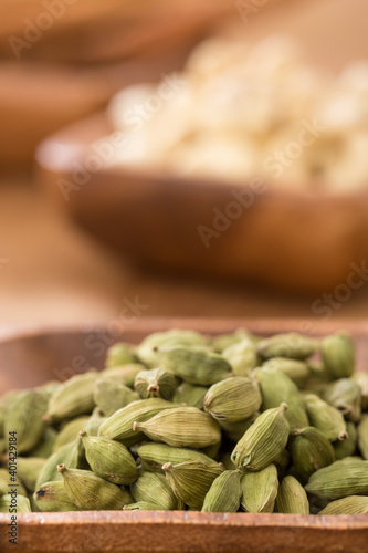 Bowl of cardamom and cashew on table.