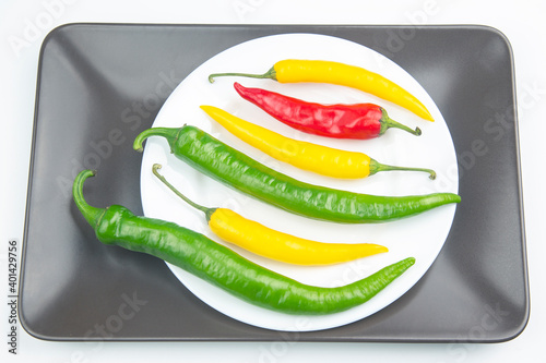 yellow, red and green hot chili on a plate. Pepper. Vegetable vitamin food.