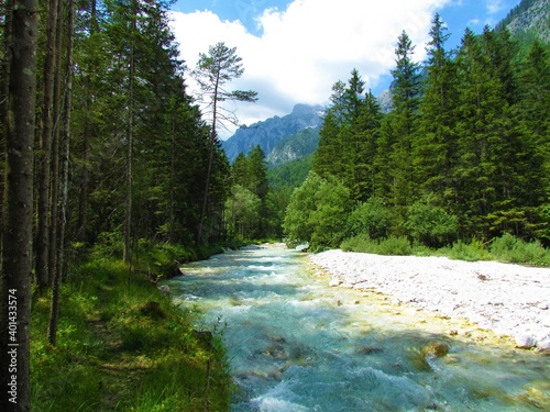 Scenic Trglavska Bistrica aline river in Vrata valley in Slovenia and mountain peaks behind