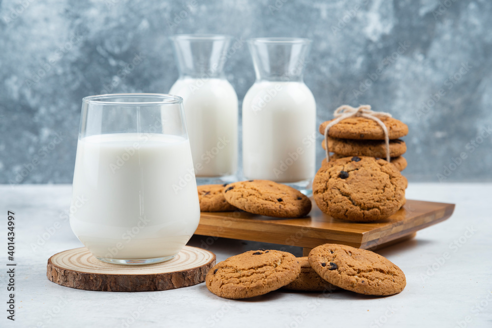A glass and jar of milk with delicious cookies A glass and jar of milk with delicious cookies