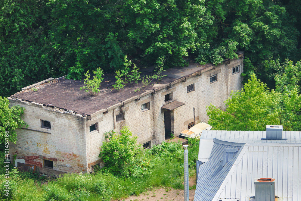 Urban lanscape with old warehouse and green trees in summer Kaunas