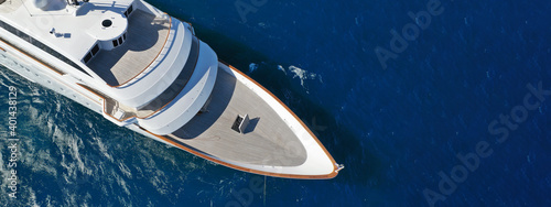 Aerial drone ultra wide photo of luxury yacht with wooden deck anchored in deep blue open ocean sea © aerial-drone