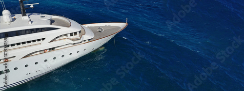 Aerial drone ultra wide photo of luxury yacht with wooden deck anchored in deep blue open ocean sea © aerial-drone