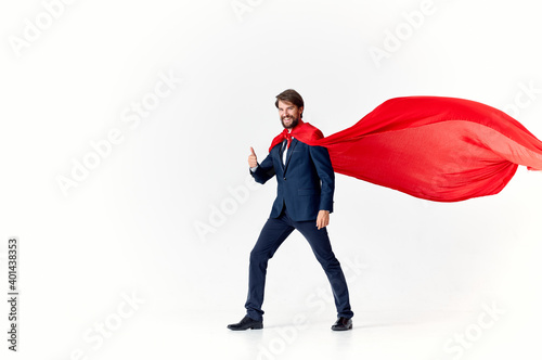 business man in a red cloak on a light background looks to the side success superhero suit