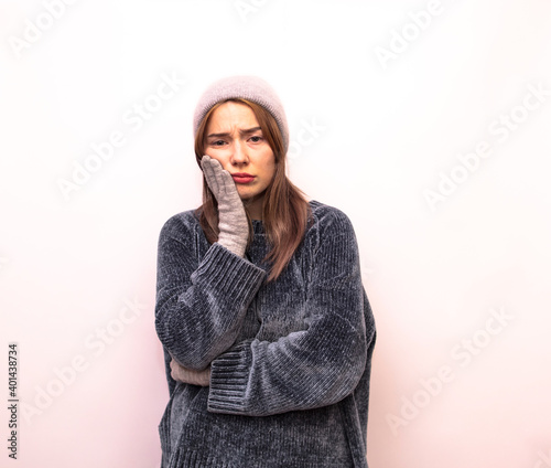  Girl holding a tooth because of pain isolated on white background