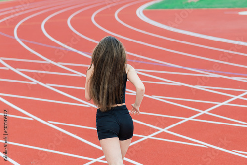 Young  beautiful girl athlete in sportswear is training at the stadium
