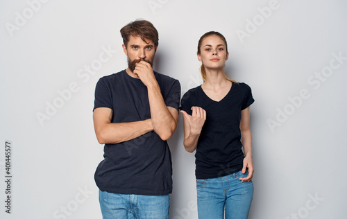 cheerful man and woman in black t-shirts studio casual clothes isolated background