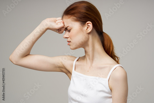 young woman touching her face with hands on a gray background health problems cosmetology acne care